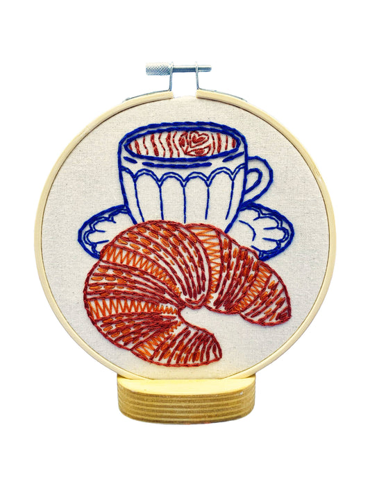 Kuvassa on croissant-aiheinen kirjontasetti (embroidery kit).