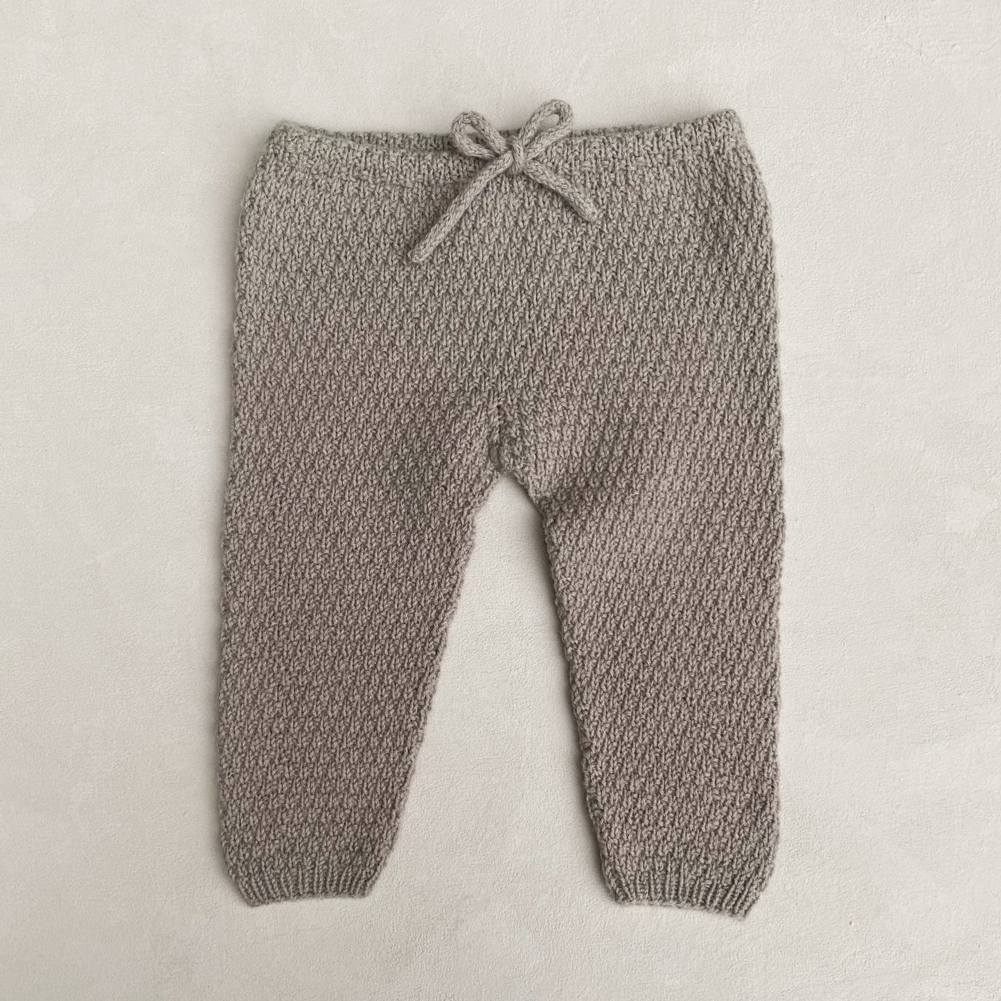 Kuvassa on Knitting for Olive (KFO) Olive Oat Pants -neuleohje (pattern).