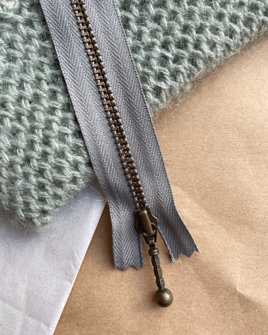 Kuvassa on PetiteKnit vetoketju (zipper) 17cm värissä Flint.