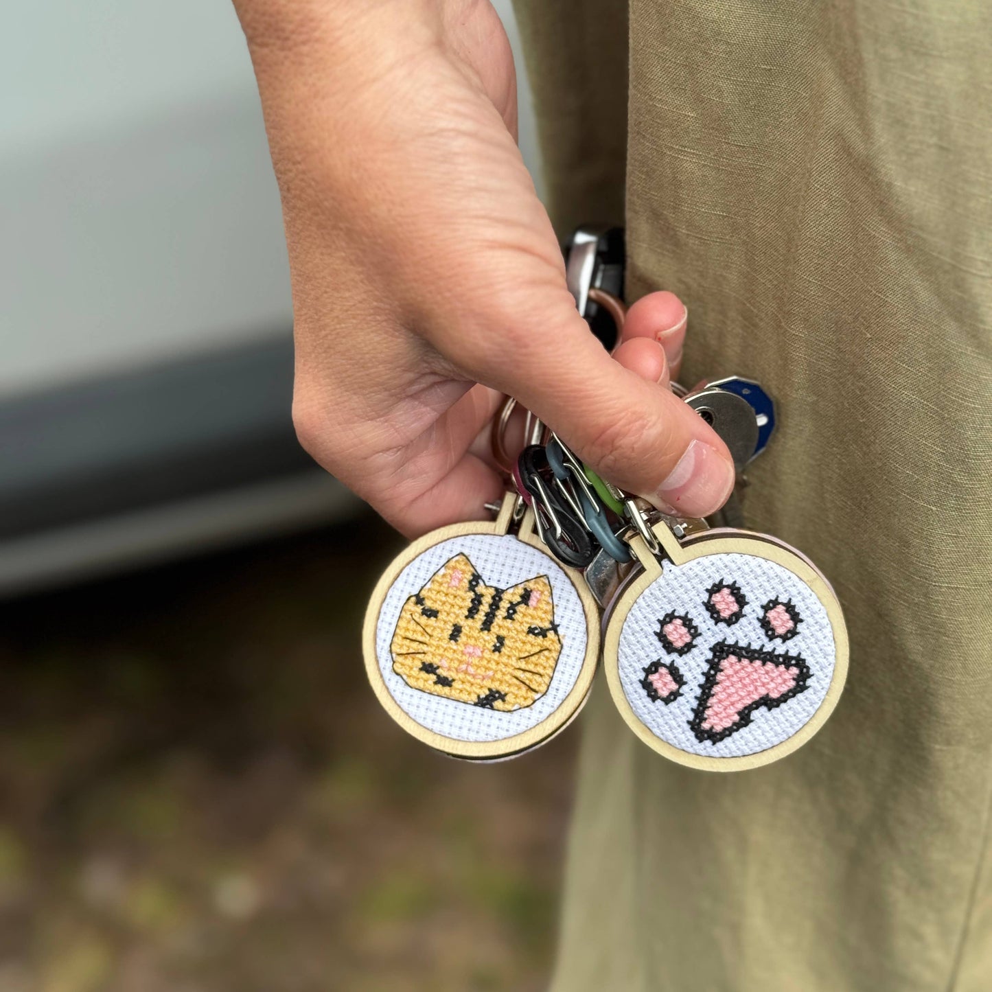 Kuvassa on The Crafty Kit Company -valmistajan ristipistotöitä roikkumassa avaimissa.