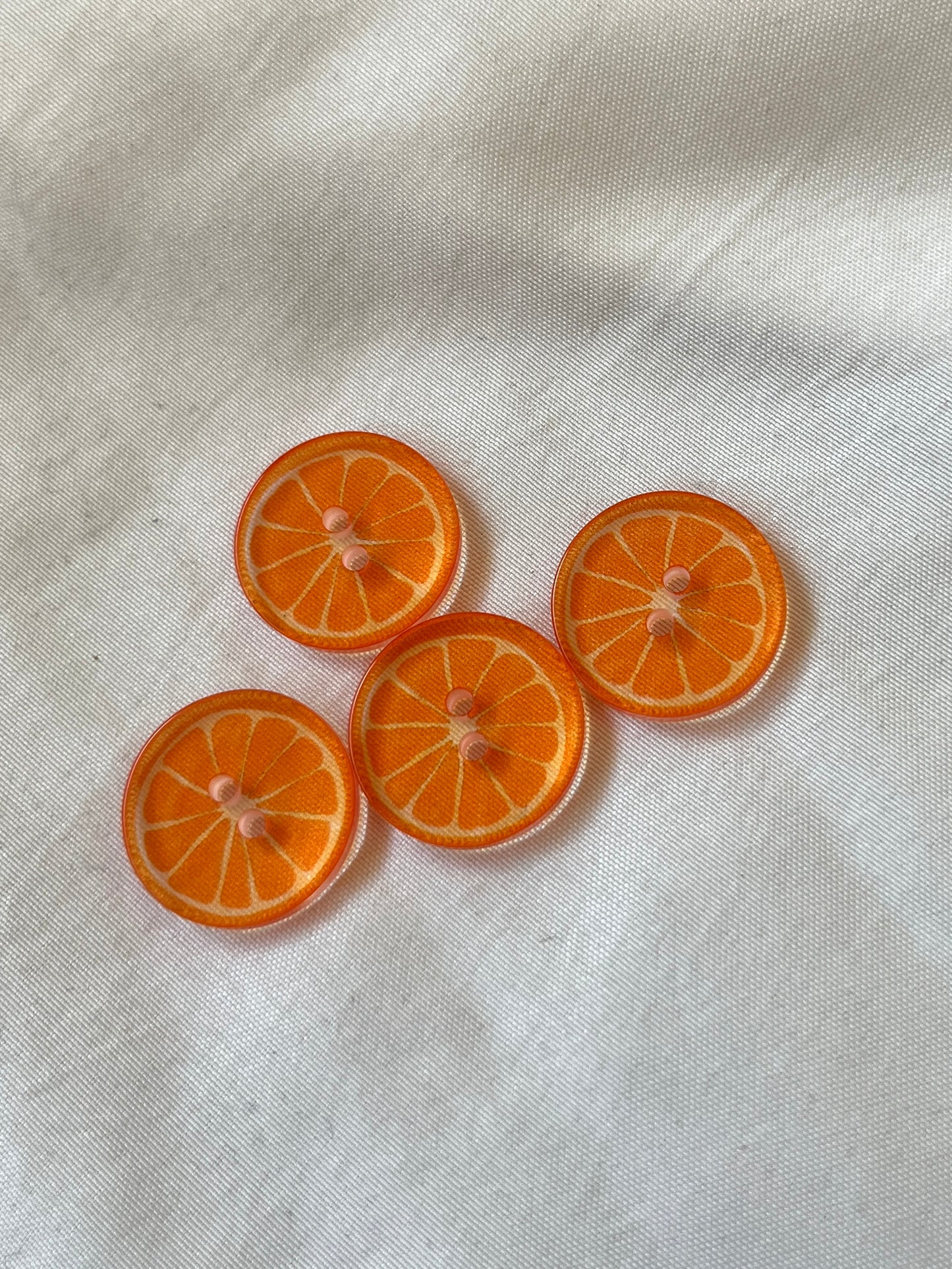 Kuvassa on appelsiinikuvioisia nappeja (buttons) vaatteisiin.