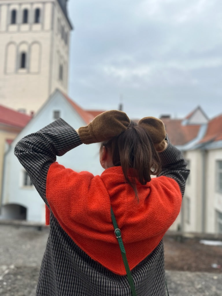 Kuvassa on yrityksen Armi yarns perustaja (nainen) takaapäin neulehuivi päällään.