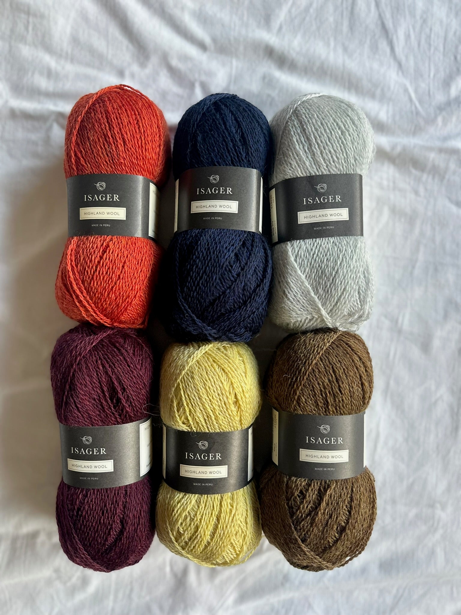 Kuvassa on Isager Highland Wool -lankakeriä kasassa.