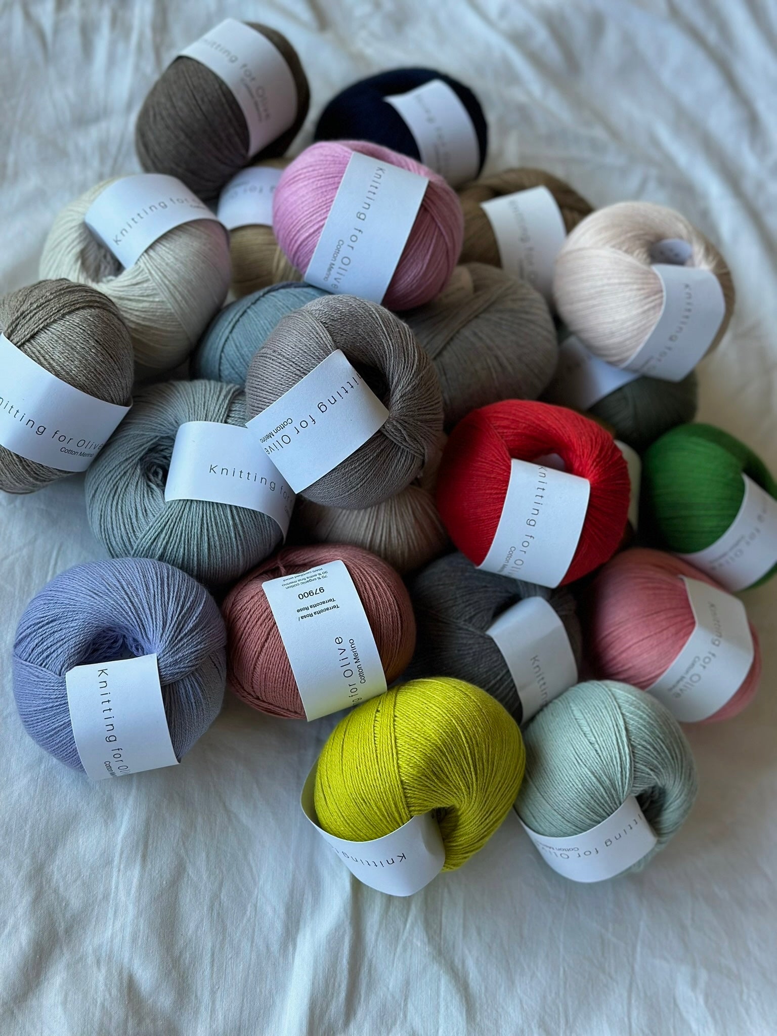 Kuvassa on erivärisiä Knitting for Olive Cotton Merino -lankoja (yarn).