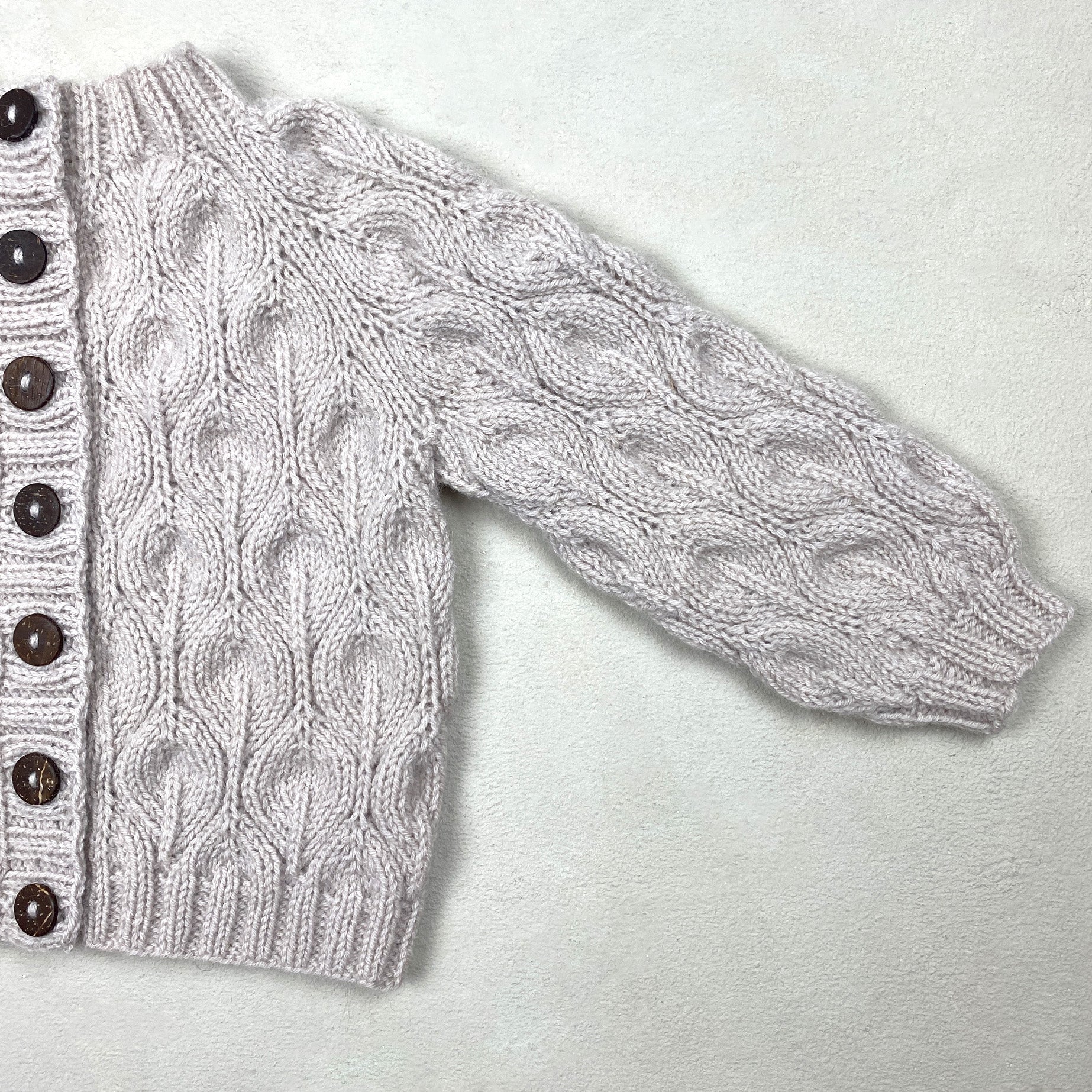 Kuvassa on Knitting for Olive (KFO) Olive Cardigan Baby -neuleohje (pattern).