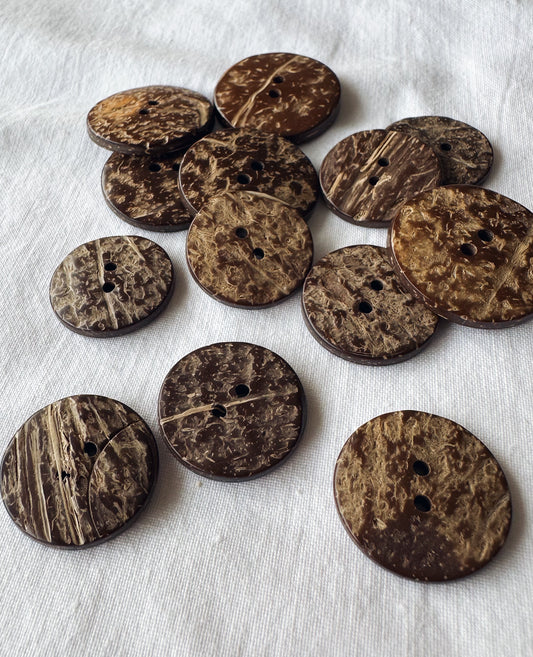Kuvassa on ruskeita kookosnappeja (button).