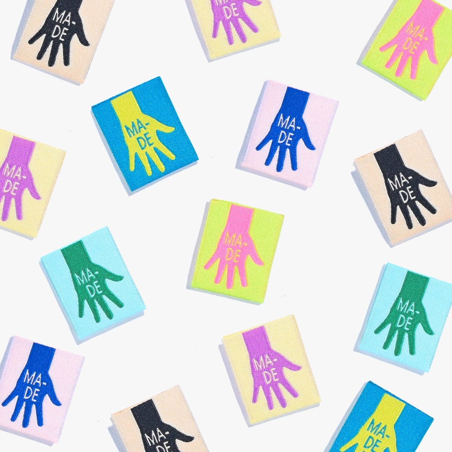 Kuvassa on Kylie & The Machine -kangasmerkit (labels), joissa on kädenjälki tekstillä Made.