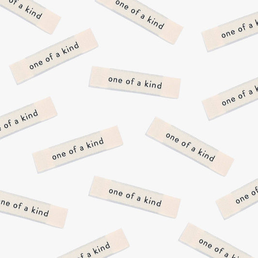 Kuvassa on Kylie & The Machine One of a kind -kangasmerkit (labels).