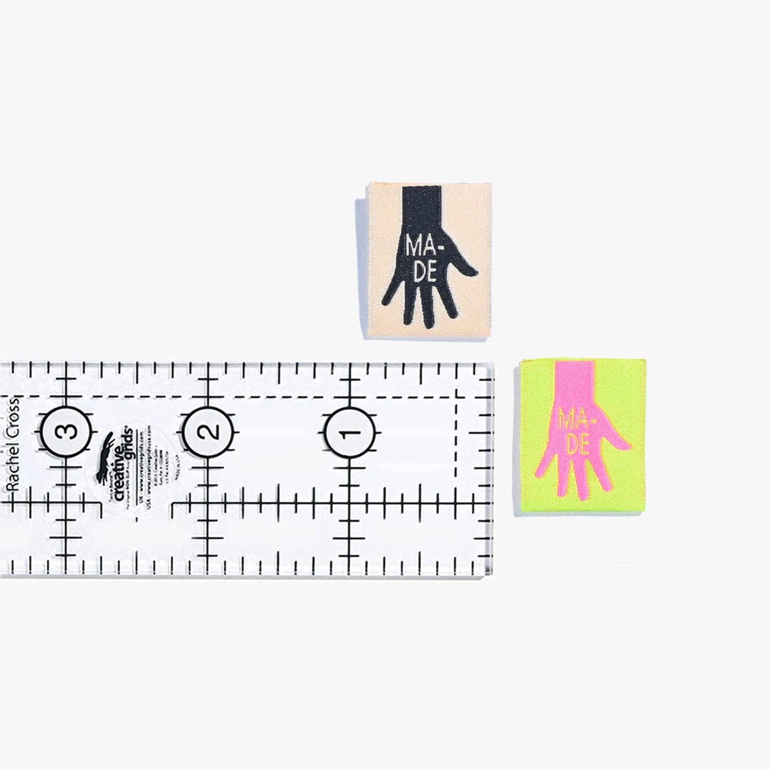 Kuvassa on Kylie & The Machine -kangasmerkit (labels), joissa on kädenjälki tekstillä Made.