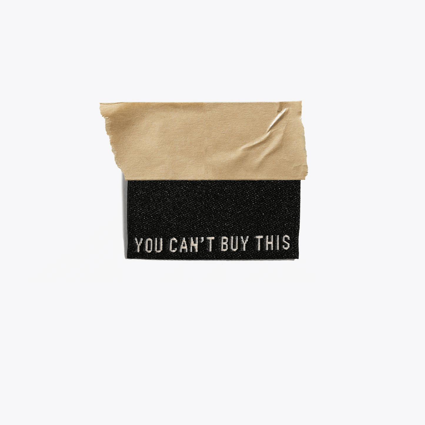 Kuvassa on Kylie & The Machine -kangasmerkit (labels) tekstillä You can't buy this.