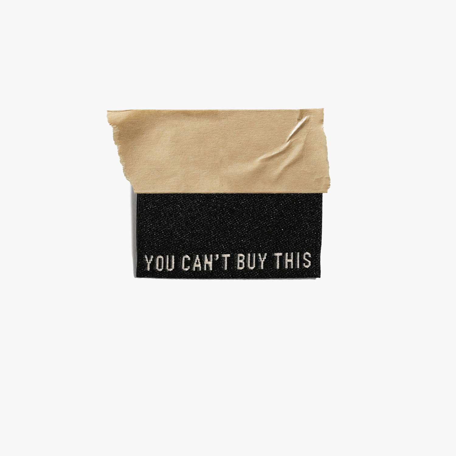 Kuvassa on Kylie & The Machine -kangasmerkit (labels) tekstillä You can't buy this.