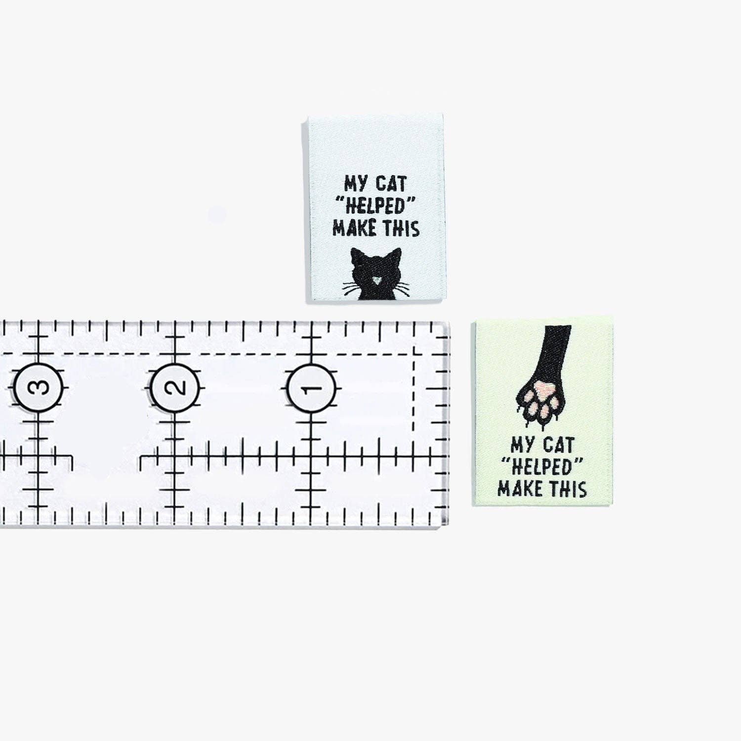 Kuvassa on Kylie & The Machine -kangasmerkit (labels) tekstillä My cat "helped" me make this.