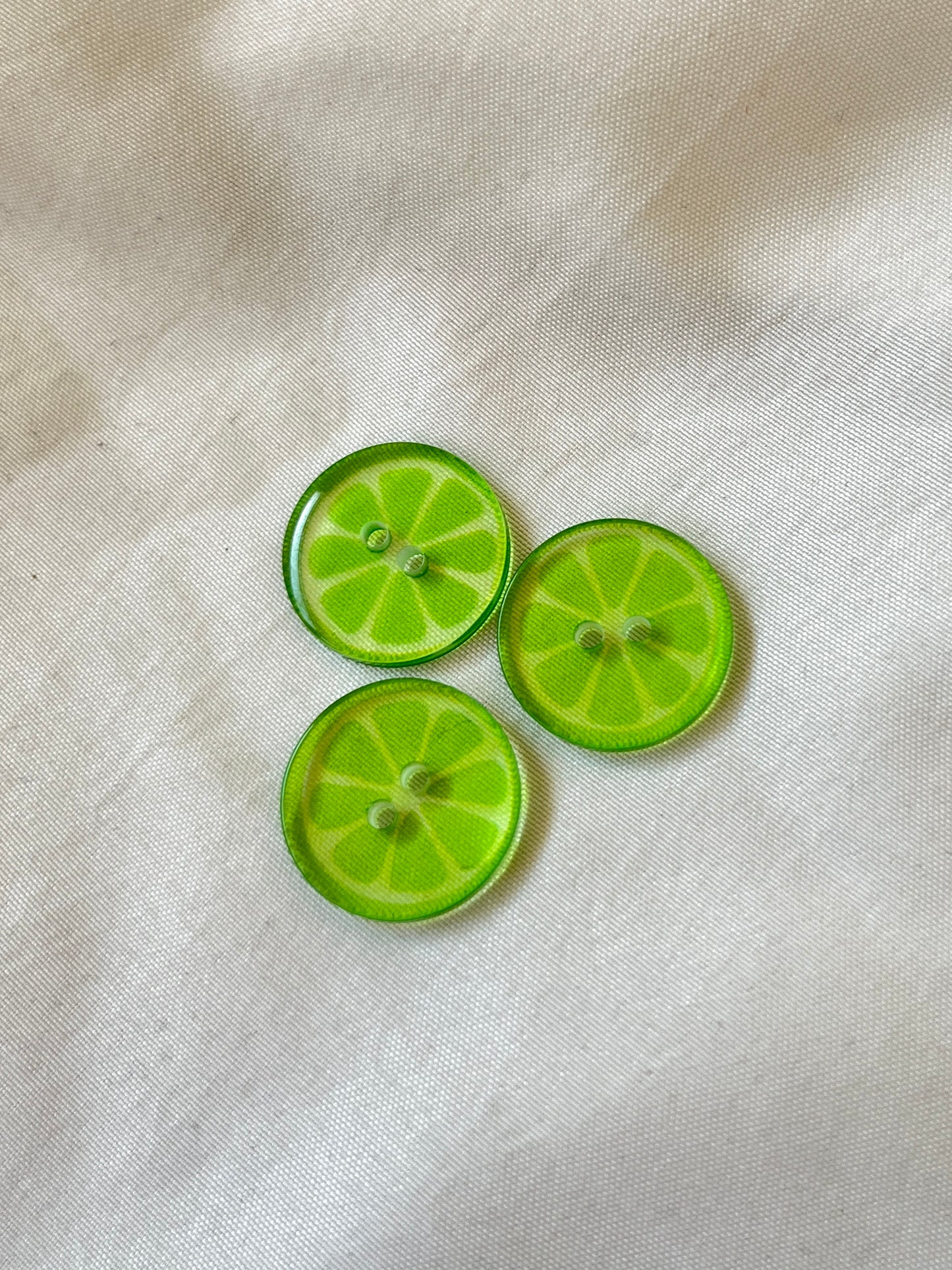 Kuvassa on limekuvioisia nappeja (buttons) vaatteisiin.