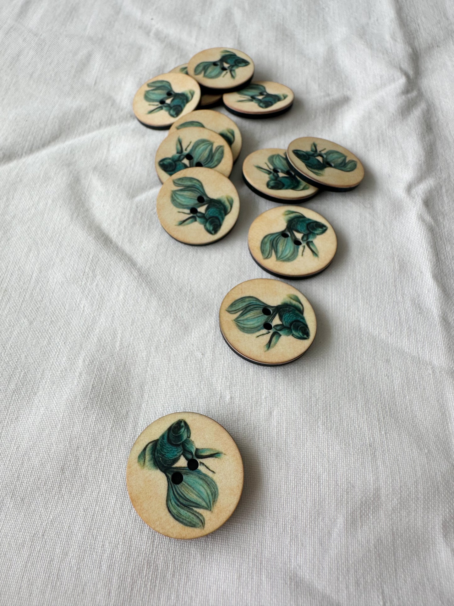Kuvassa on nappeja (buttons), joissa on kultakalan kuva.