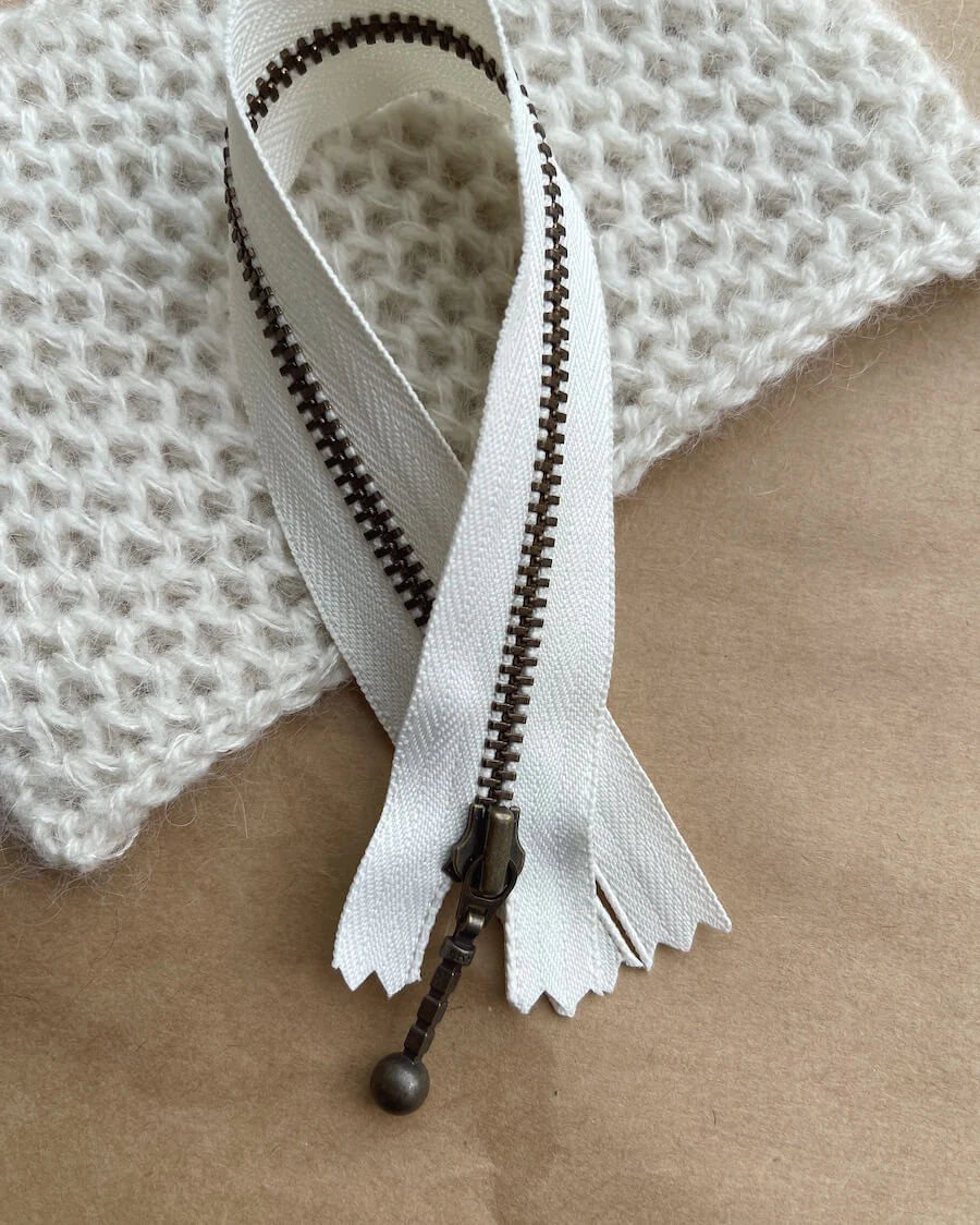 Kuvassa on PetiteKnit vetoketju (zipper) 23cm värissä Mother of pearl.