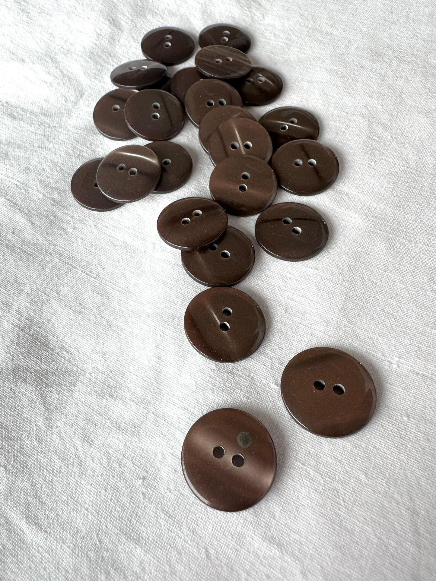 Kuvassa on ruskea nappi (button), jonka halkaisija on 18 millimetriä.