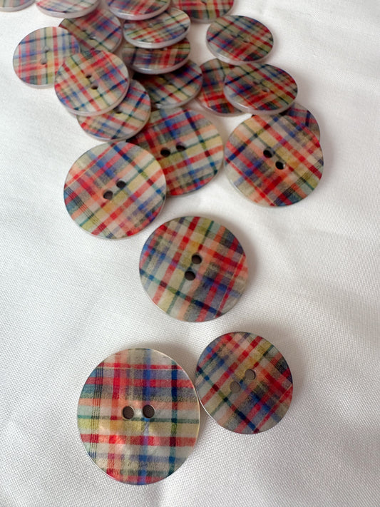 Kuvassa on on erikokoisia ruudullisia nappeja. 