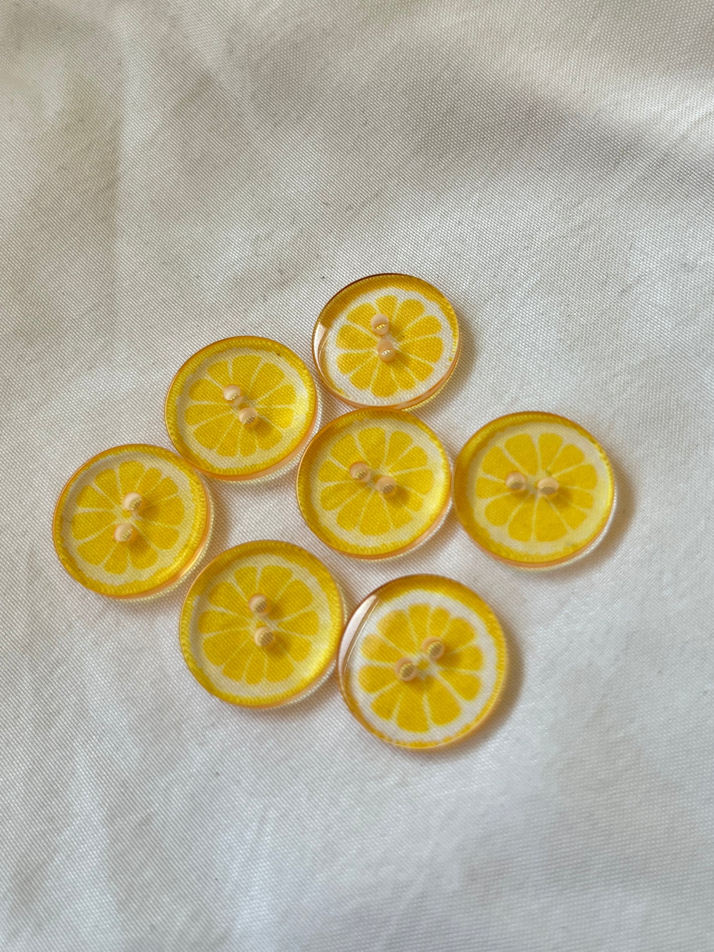 Kuvassa on sitruunakuvioisia nappeja (buttons) vaatteisiin.
